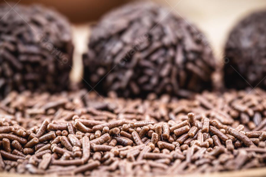 Brigadeiro tradicional brasileiro com granulado de chocolate sobre base marrom