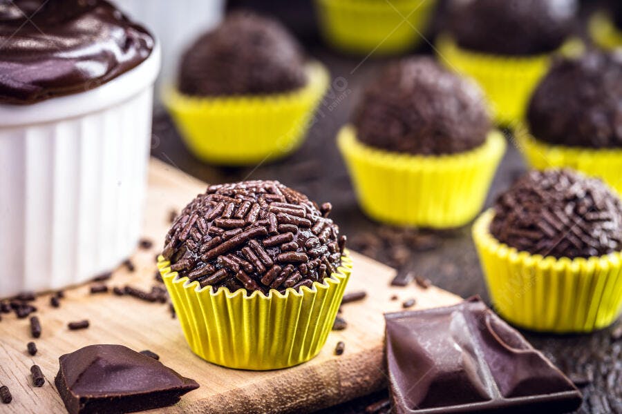 Brigadeiro brasileiro em forminhas amarelas com granulado e pedaços de chocolate
