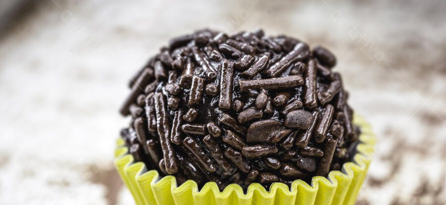 Brigadeiro de chocolate brasileiro com granulado em copinho de papel amarelo claro