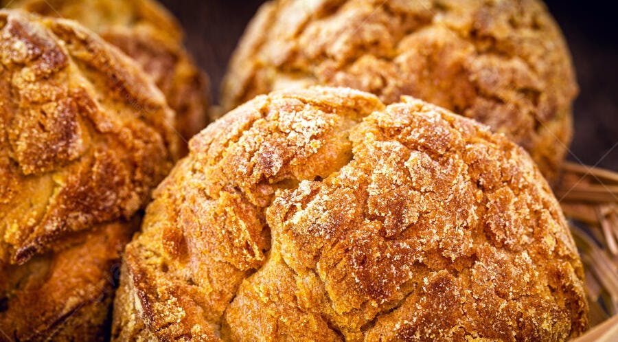 Pães de queijo caseiros dourados e crocantes em cesta de vime