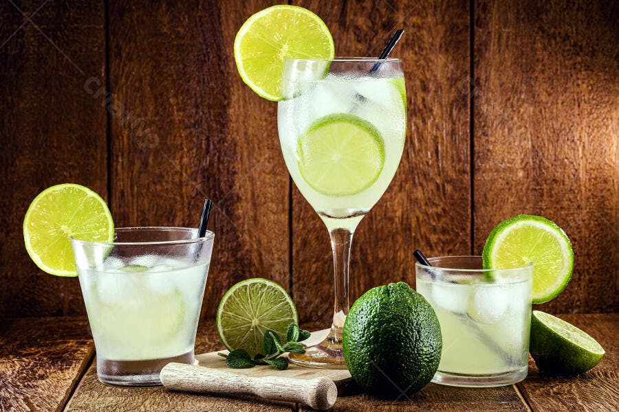 Bebidas refrescantes de limão com gelo e limões frescos em mesa de madeira escura