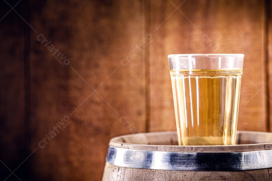 Copo de cachaça tradicional sobre barril de madeira rústico
