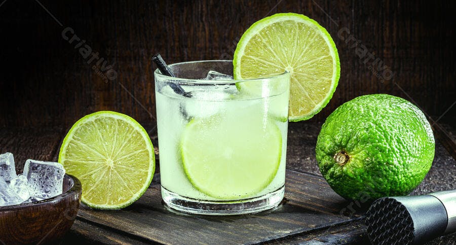 Caipirinha de limão fresca com gelo em mesa de madeira rústica