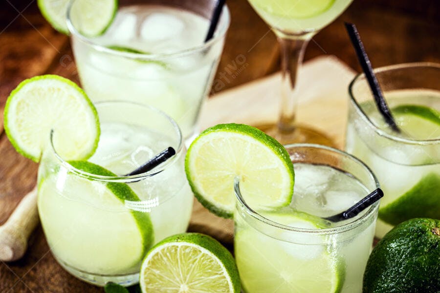 Caipirinhas refrescantes com gelo e limão em mesa de madeira rústica
