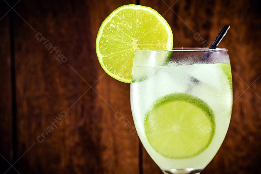 Bebida refrescante com limão siciliano e gelo em fundo de madeira rústico