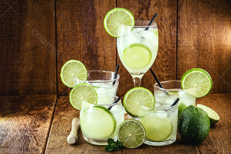 Caipirinhas refrescantes com limão e gelo em mesa de madeira rústica