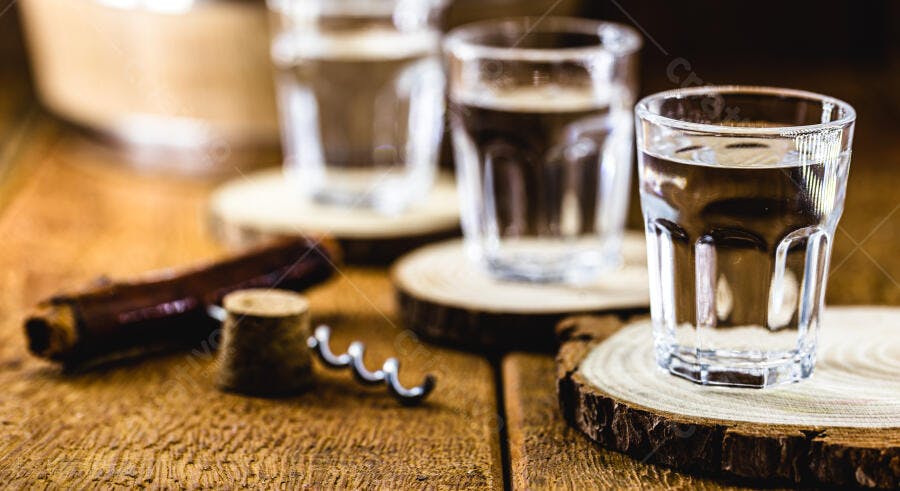 Copos de cachaça e saca-rolhas em mesa de madeira rústica bebida transparente