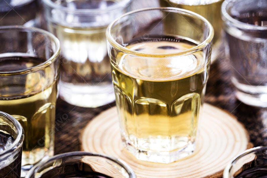 Copos de cachaça dourada em degustação de bebidas típicas brasileiras