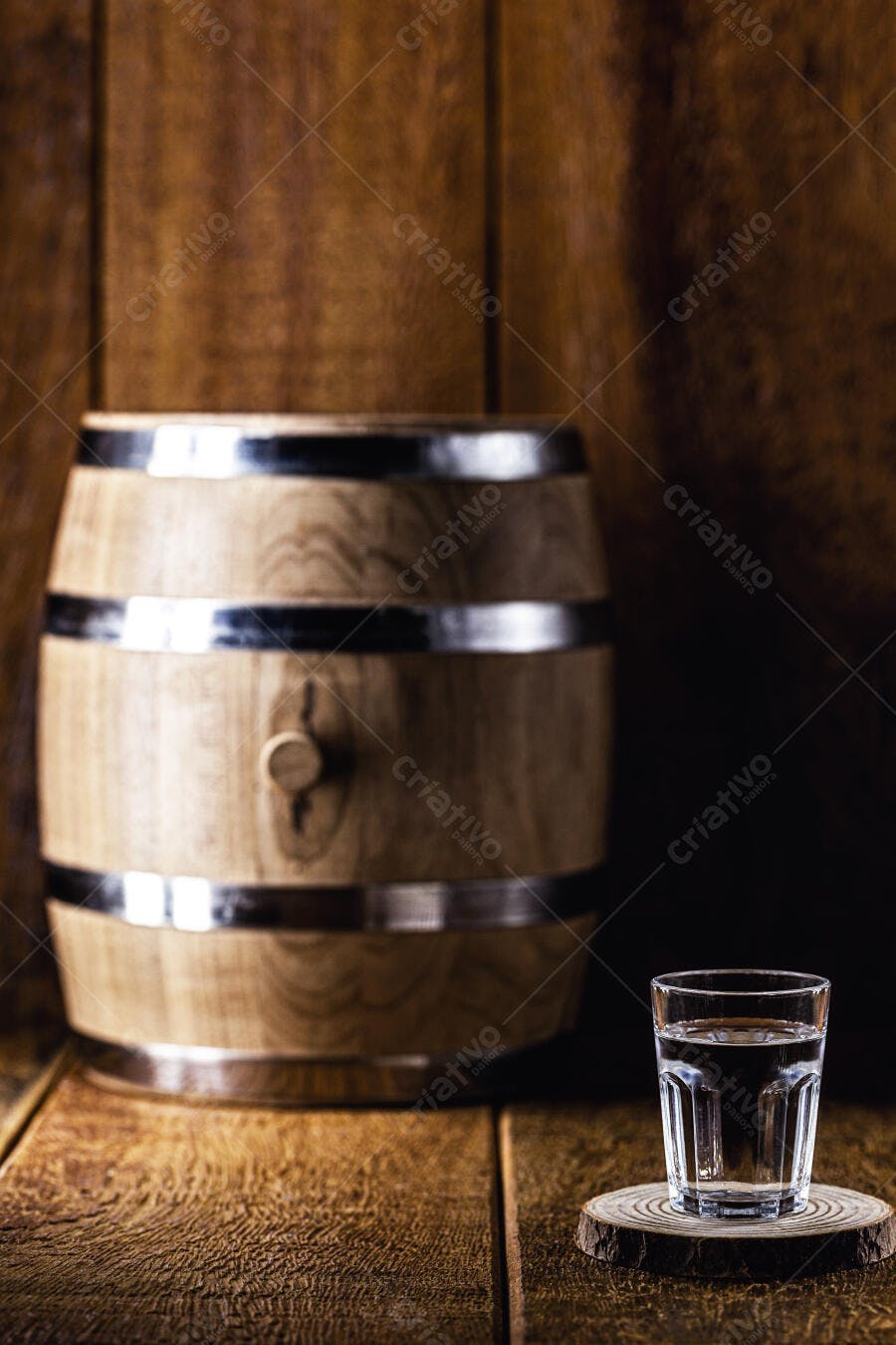 Barril de madeira rústico e copo de destilado em ambiente tradicional