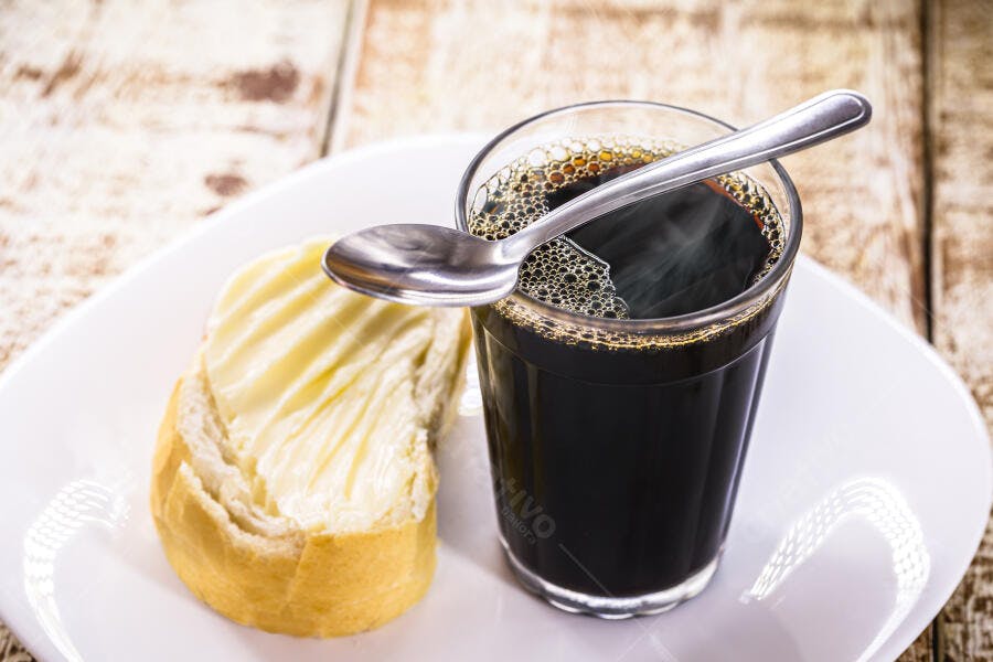Café quente em copo americano e pão com manteiga fresco no café da manhã