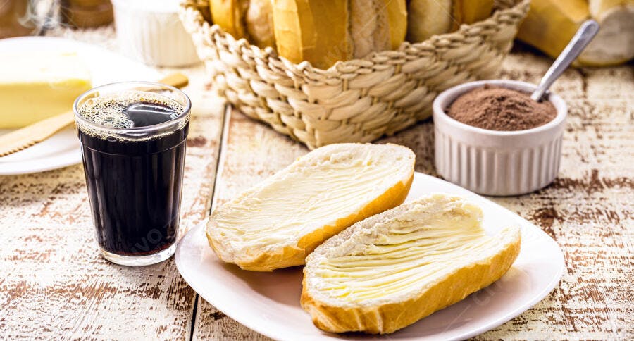 Pão francês com manteiga café e chocolate em pó para o café da manhã