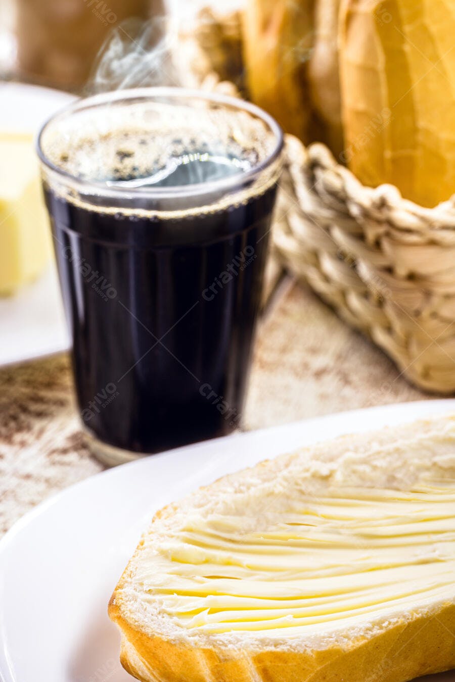 Copo de café quente com pão e manteiga fresca para um café da manhã acolhedor