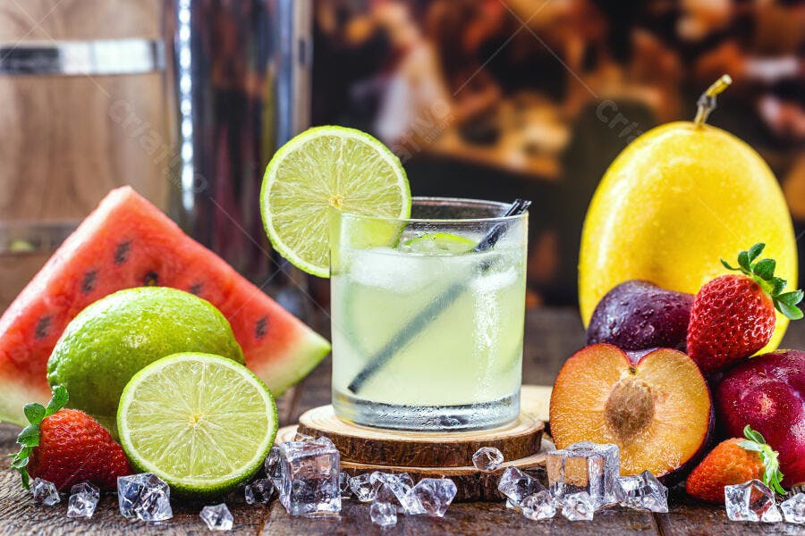 Coquetel refrescante de limão e frutas tropicais com gelo em mesa de madeira