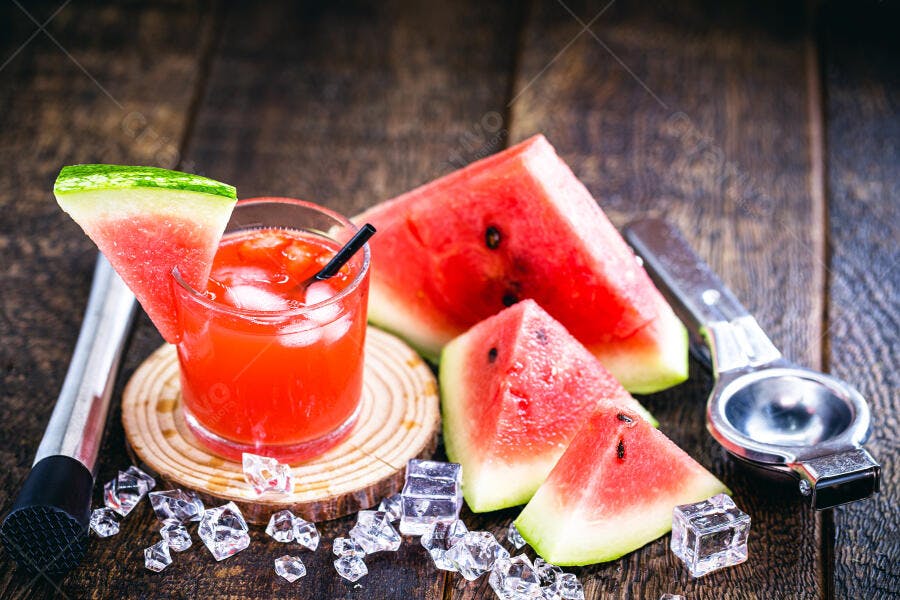 Suco de melancia gelado e fatias frescas em mesa de madeira rústica com gelo verão