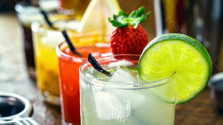 Coquetéis coloridos de frutas com lima e morango em bar