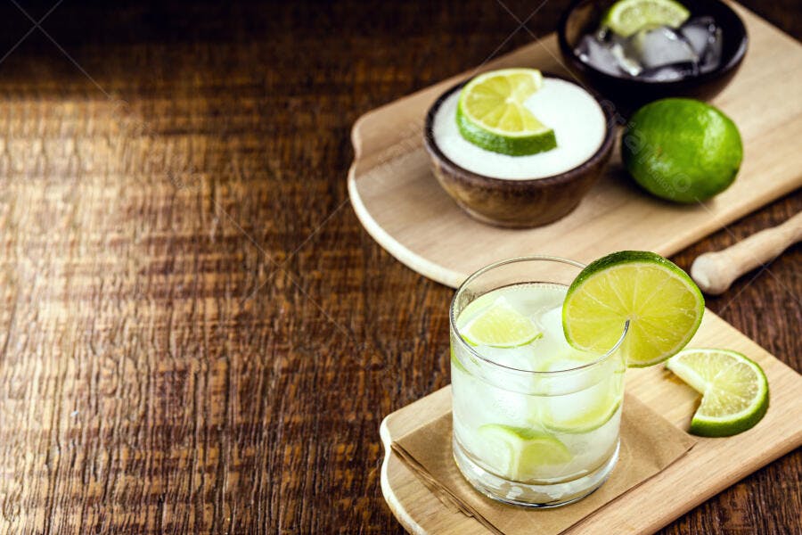 Caipirinha refrescante com limão, açúcar e gelo em mesa de madeira rústica