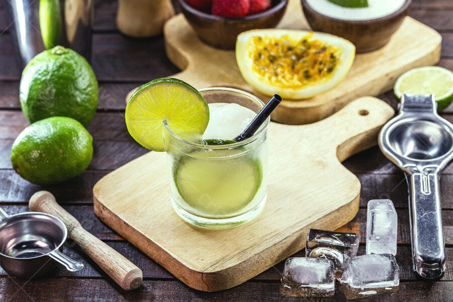 Caipirinha refrescante com limão e gelo em mesa de madeira rústica