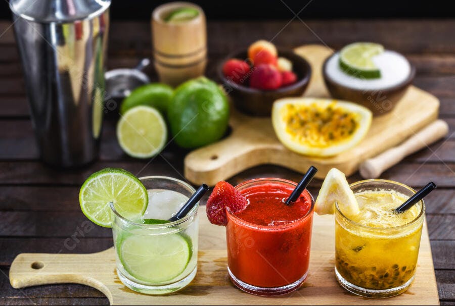Coquetéis de frutas tropicais refrescantes com limão morango maracujá e gelo em madeira