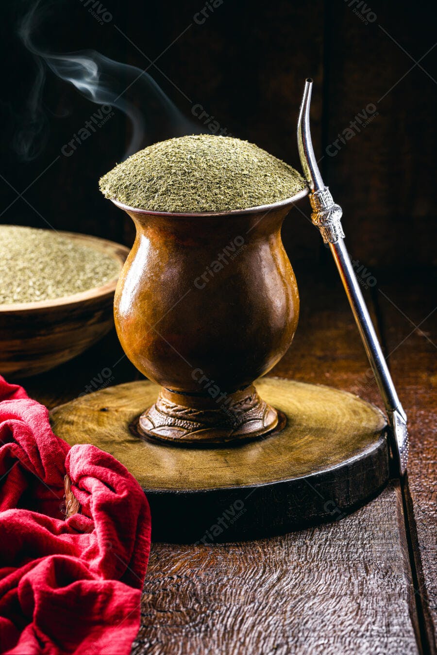 Chimarrão verde vaporizando em cuia de madeira com bomba prata na mesa rústica