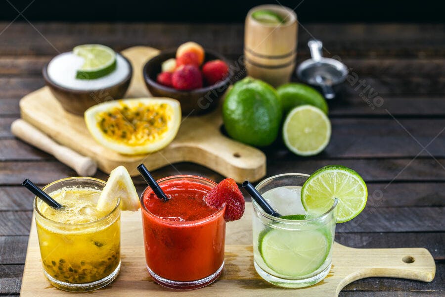 Bebidas tropicais coloridas de frutas frescas em mesa de madeira rústica