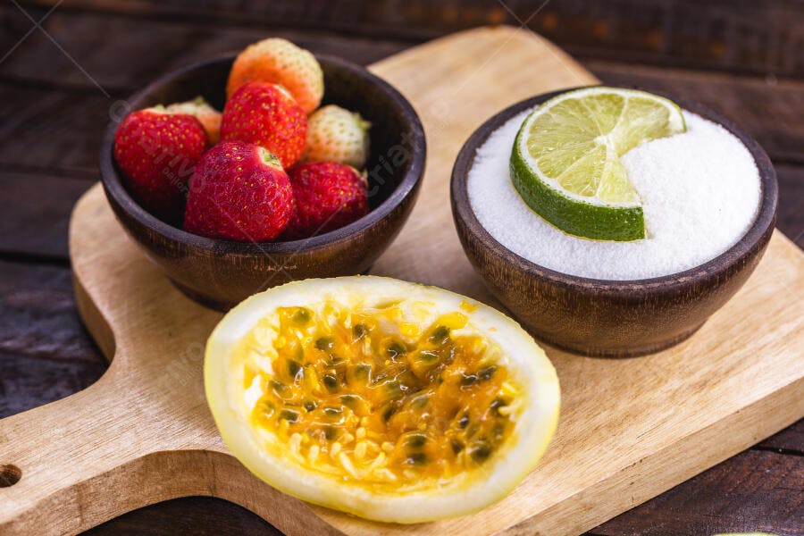 Frutas frescas morangos maracujá e limão com açúcar em tábua de madeira
