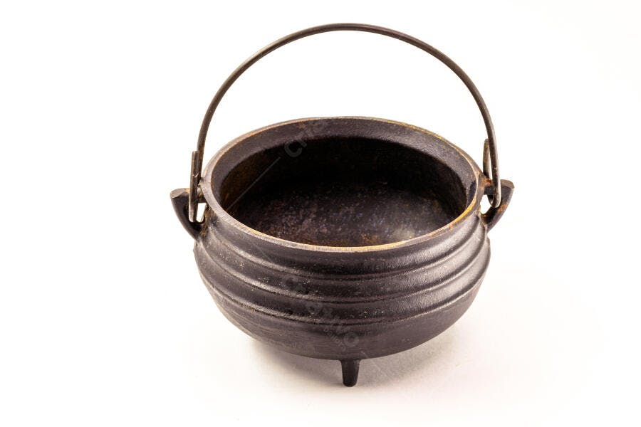 Caldeirão de ferro fundido preto rústico em fundo branco isolado