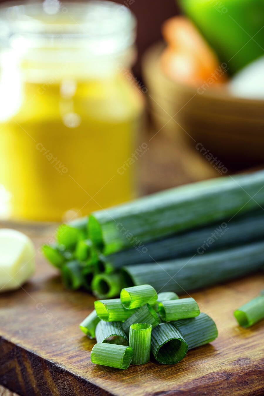 Cebolinha verde picada em tábua de madeira com alho e azeite