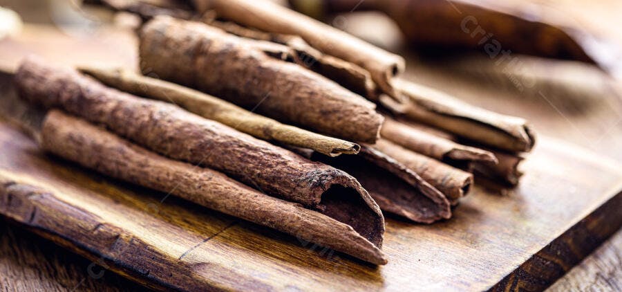 Canela em pau aromática em tábua de madeira rústica