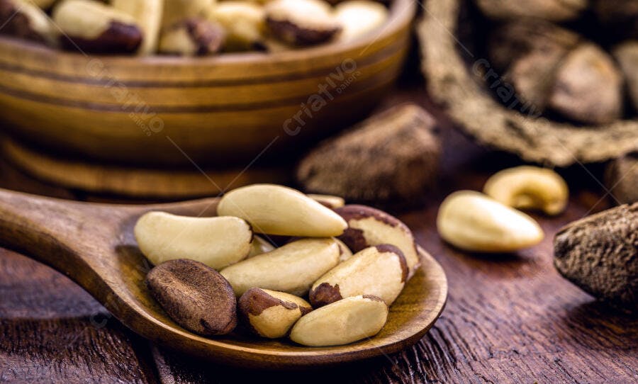 Castanhas-do-Pará frescas em colher de madeira e tigela rústica