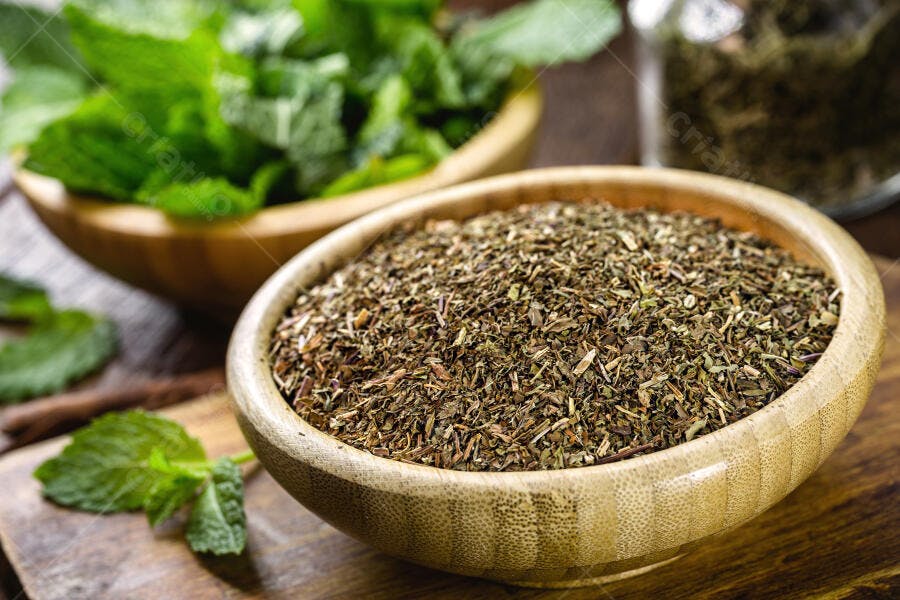 Hortelã seca e fresca em tigelas de madeira com ervas aromáticas