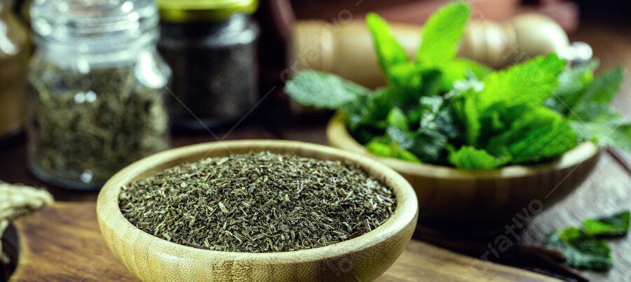 Ervas secas e hortelã fresca em tigelas de madeira na cozinha rústica
