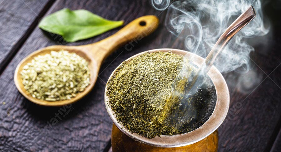 Chimarrão quente tradicional na mesa de madeira escura com erva mate
