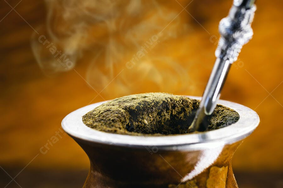 Cuia de mate chimarrão com erva-mate e bombilla soltando vapor closeup
