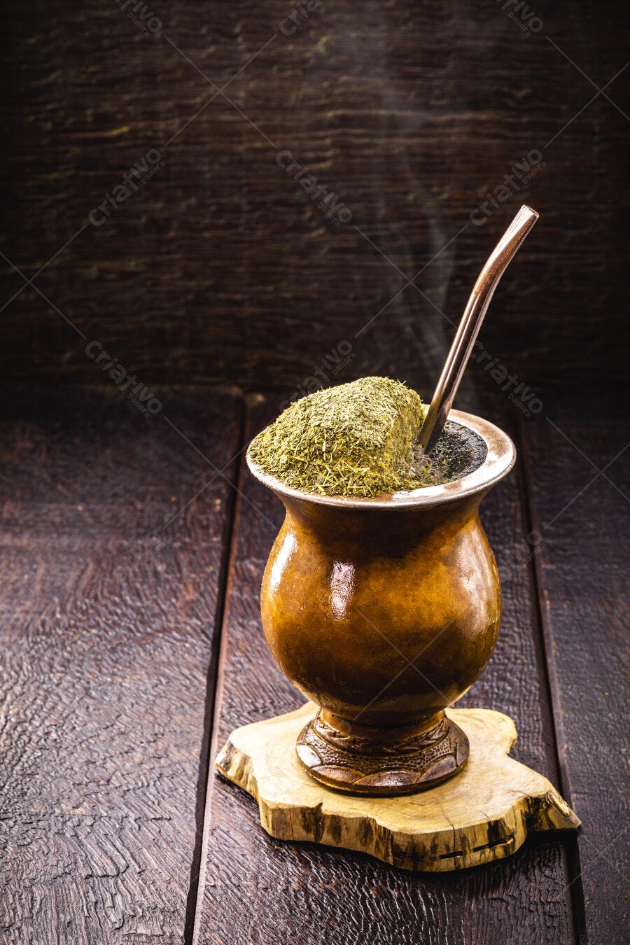Chimarrão fumegante em cuia de porongo sobre mesa de madeira rústica