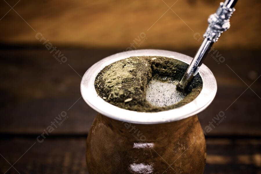 Chimarrão tradicional em cuia de madeira com erva-mate e bomba metálica sobre mesa rústica