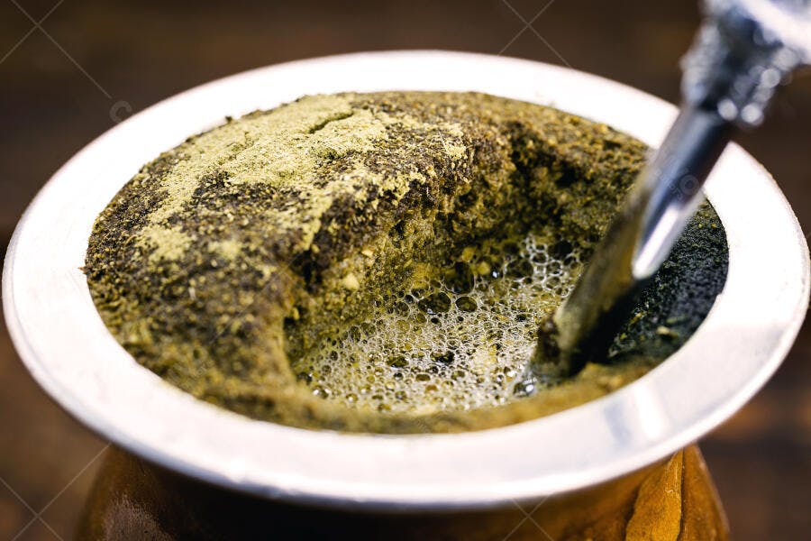 Chimarrão verde espumante em cuia de madeira com bomba metálica