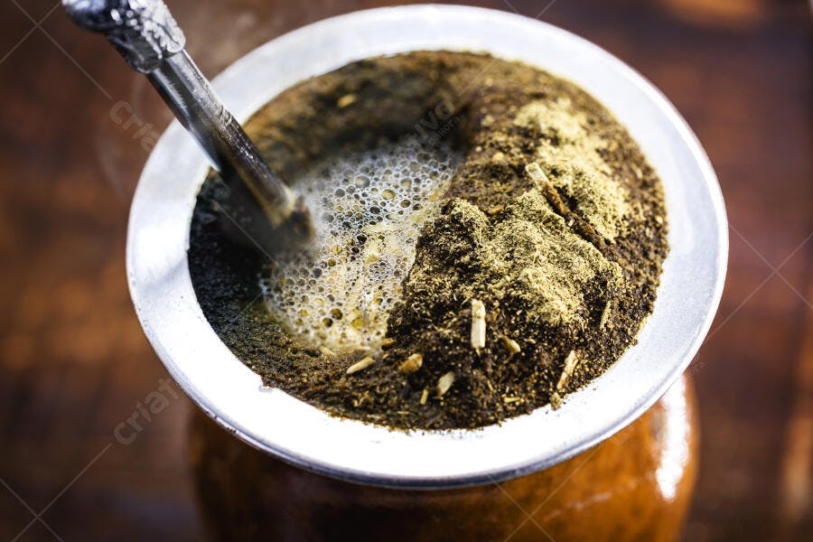 Chimarrão tradicional com erva-mate e bombilla em cuia marrom quente