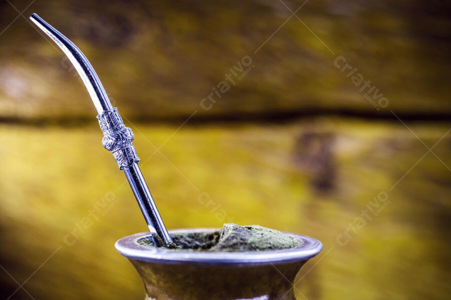 Chimarrão tradicional em cuia de madeira com bomba de prata sobre fundo rústico