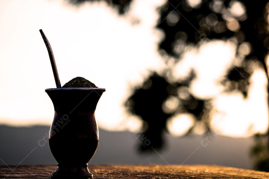 Cuia de chimarrão e bomba na mesa rústica ao entardecer