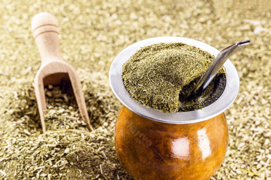 Erva-mate chimarrão em cuia marrom com bombilla e colher de madeira