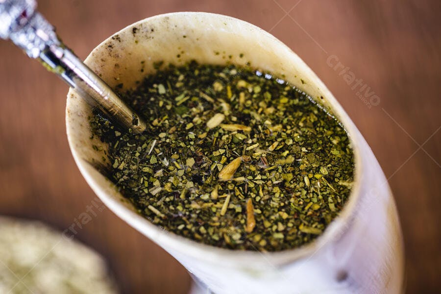Chimarrão tradicional com erva-mate e bomba em cuia de madeira closeup