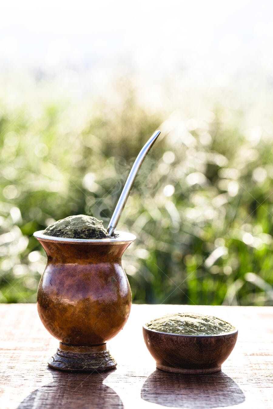 Chimarrão fresquinho em cuia e tigela de madeira ao ar livre com vapor