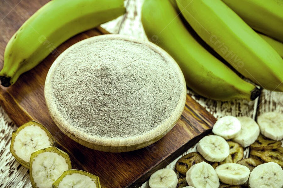 Farinha de banana verde em tigela com bananas frescas e chips crocantes