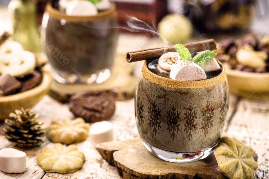 Chocolate quente cremoso com marshmallows canela e biscoitos natalinos mesa rústica