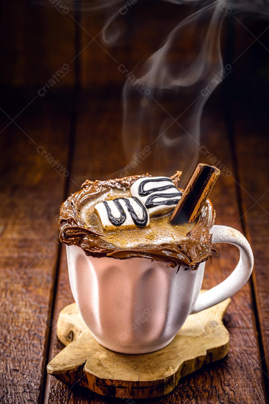 Chocolate quente cremoso com marshmallows e canela em caneca rosa sobre madeira rústica