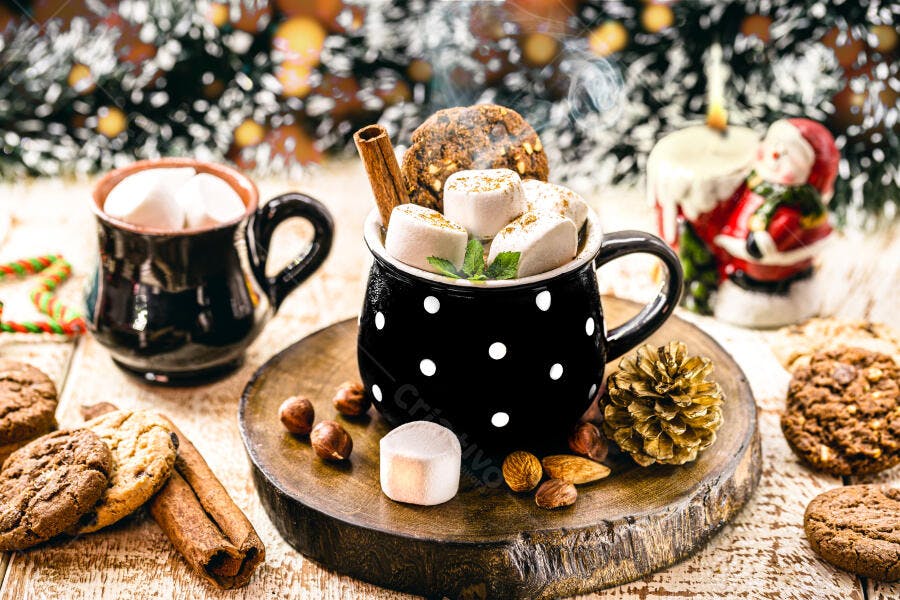 Caneca preta de chocolate quente com marshmallows e biscoitos natalinos