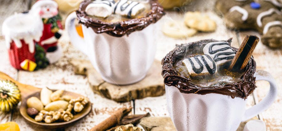Chocolate quente com marshmallows e especiarias em cenário natalino