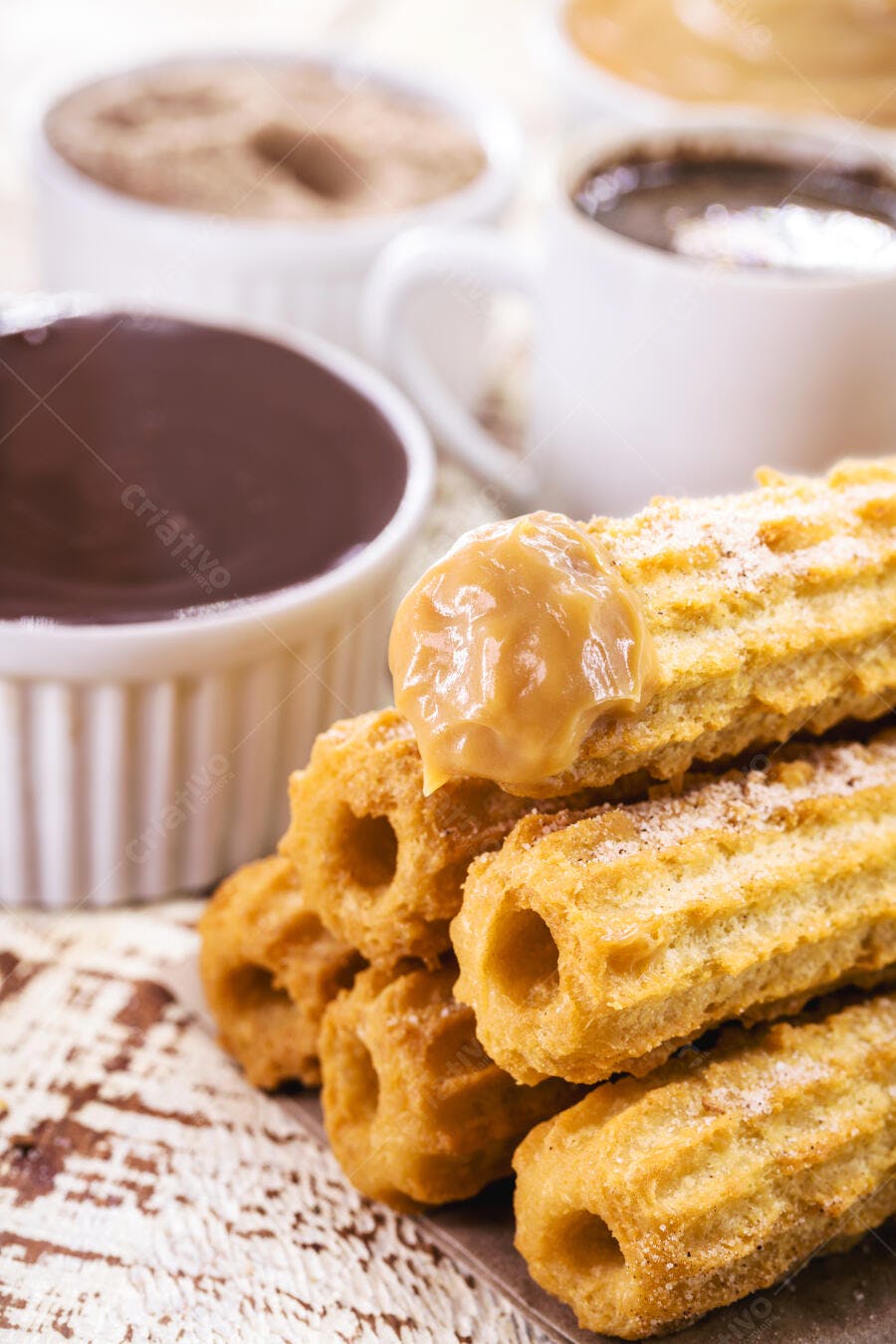 Churros dourados com doce de leite e açúcar para café da manhã