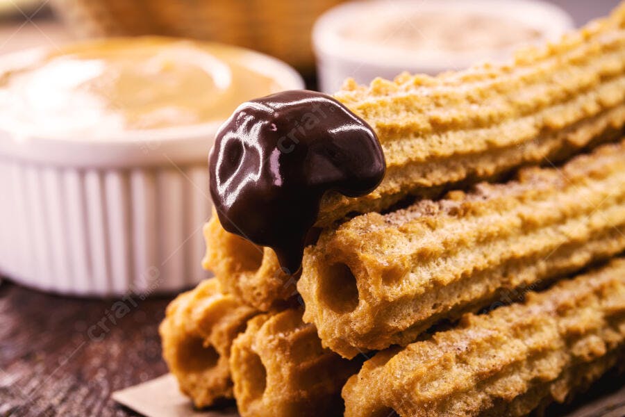 Churros dourados crocantes com calda de chocolate e doce de leite cremoso