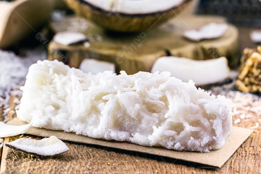 Cocada brasileira artesanal branca cremosa com coco fresco em madeira rústica